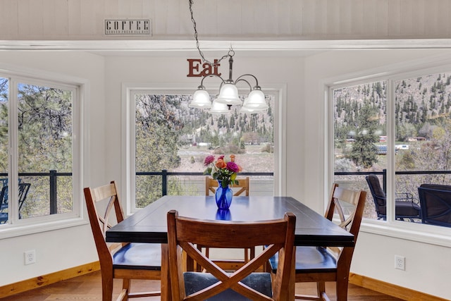390 Dairy Ln, Superior, MT 59872 - dining room featuring a chandelier, baseboards, and wood finished floors