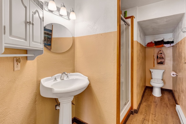 390 Dairy Ln, Superior, MT 59872 - full bath with a baseboard radiator, wood finished floors, a stall shower, toilet, and a textured wall