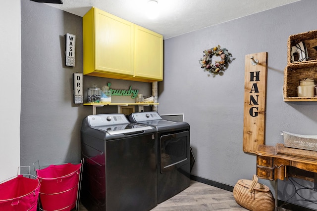 390 Dairy Ln, Superior, MT 59872 - laundry room with independent washer and dryer, cabinet space, light wood-type flooring, and baseboards