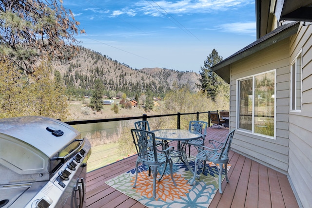 390 Dairy Ln, Superior, MT 59872 - wooden deck featuring outdoor dining area, a mountain view, and area for grilling