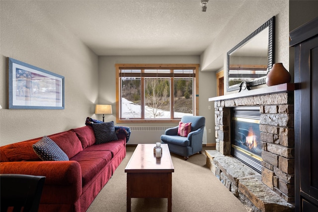 living area featuring a textured ceiling, a textured wall, carpet floors, and a fireplace