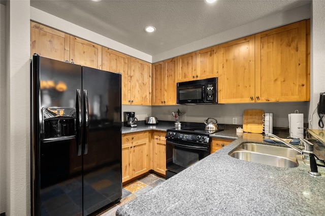 kitchen featuring dark stone countertops, recessed lighting, black appliances, a sink, and a textured ceiling