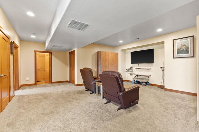 living area with baseboards, visible vents, and light carpet