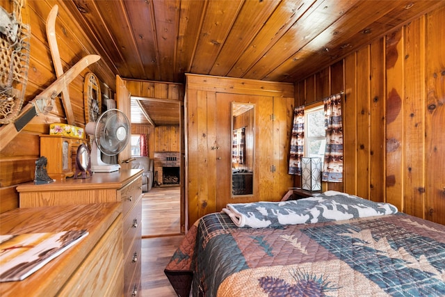 bedroom featuring wood finished floors, wooden walls, and wood ceiling