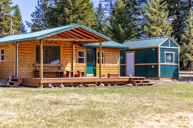 view of front facade with metal roof and a front lawn