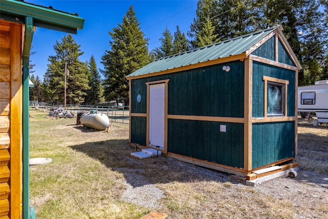 view of outbuilding featuring fence and an outbuilding