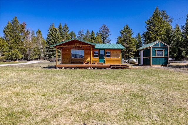 log cabin with metal roof, a front lawn, a wooden deck, and log veneer siding