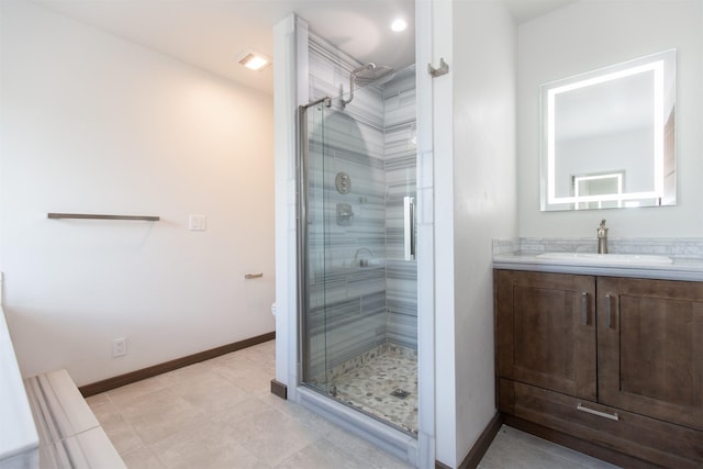full bath featuring toilet, a shower stall, vanity, and baseboards