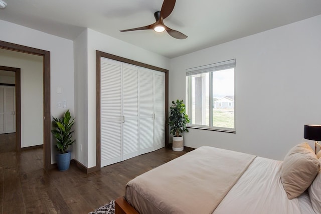 bedroom with a closet, dark wood-style flooring, a ceiling fan, and baseboards