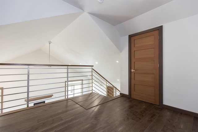 additional living space featuring baseboards, wood finished floors, and lofted ceiling