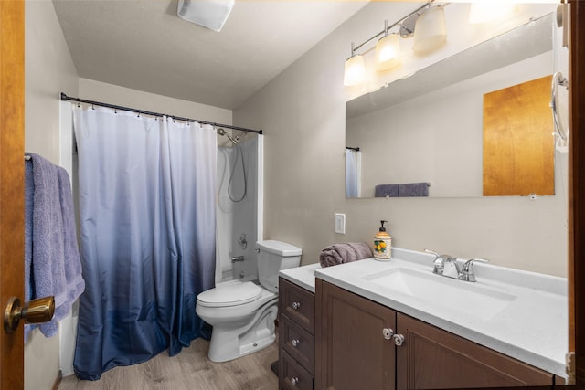 full bathroom with wood finished floors, shower / bath combination with curtain, toilet, and vanity