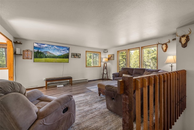 living area with baseboards, wood finished floors, and a textured ceiling
