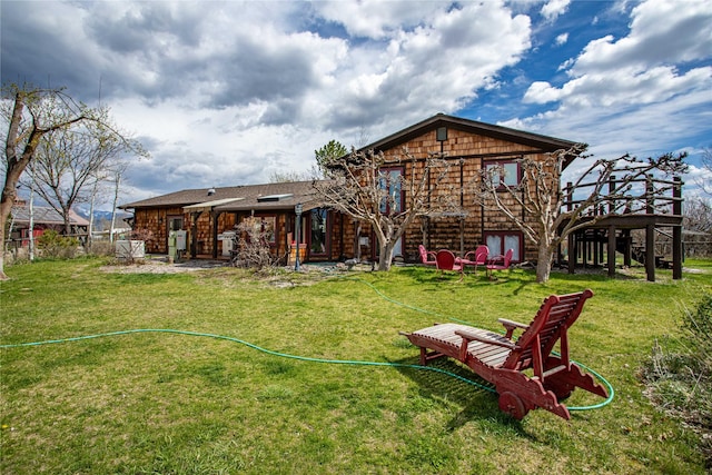 rear view of house featuring a yard and fence