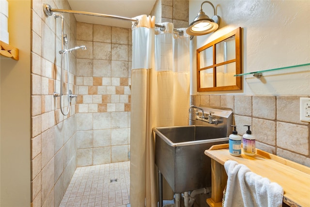 bathroom with tile walls, a stall shower, and a sink