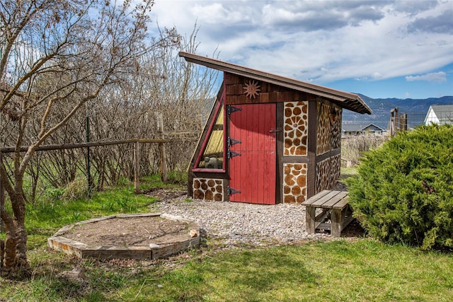 view of shed with a mountain view and fence