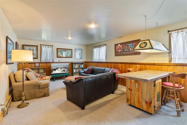 living area featuring wainscoting, wood walls, and light colored carpet