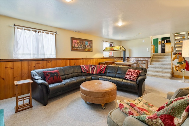 living area with a wainscoted wall, carpet flooring, and a wealth of natural light