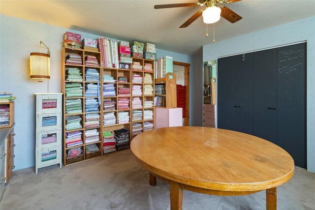 carpeted dining space with a ceiling fan