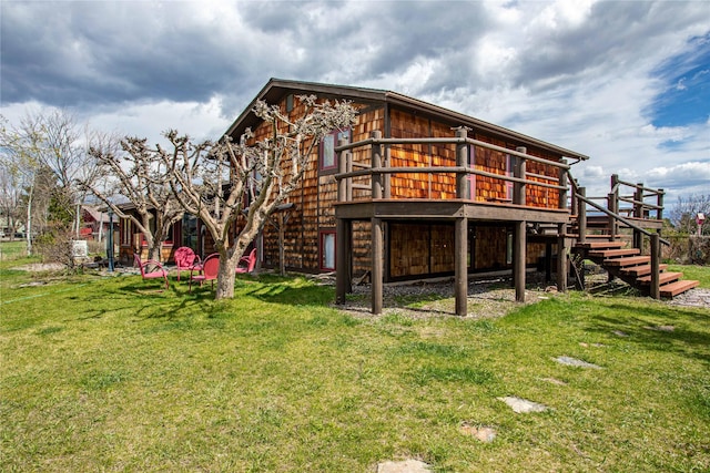 back of property featuring a lawn, stairs, and a wooden deck