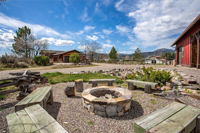 view of yard featuring fence, a fire pit, and a mountain view