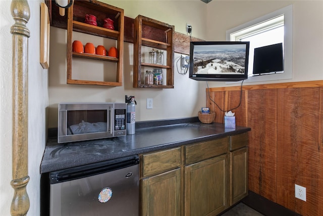 bar featuring stainless steel microwave and fridge
