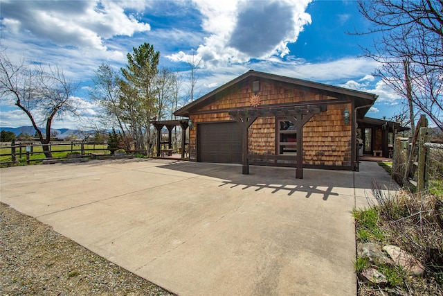 view of property exterior featuring fence, a mountain view, and an attached garage