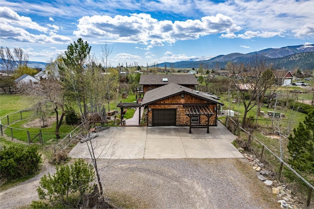 exterior space with fence, concrete driveway, and a mountain view