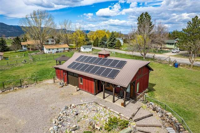7850 Stegner Dr, Missoula, MT 59808 - view of front of house with roof mounted solar panels, a mountain view, a metal roof, an outbuilding, and board and batten siding