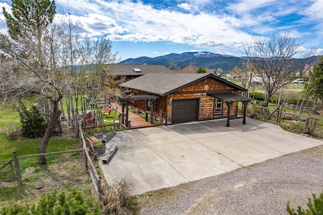view of front of home featuring a mountain view, driveway, an attached garage, and fence
