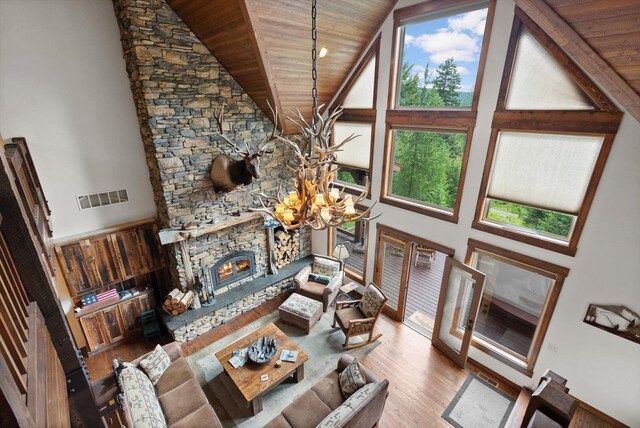 living room featuring wood ceiling, a chandelier, high vaulted ceiling, and visible vents