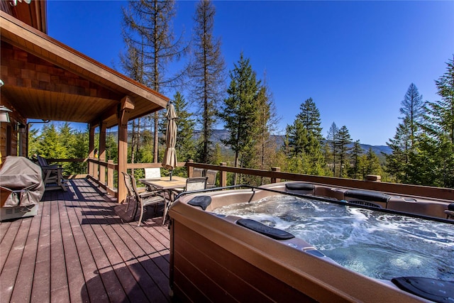 wooden terrace with outdoor dining area and a hot tub