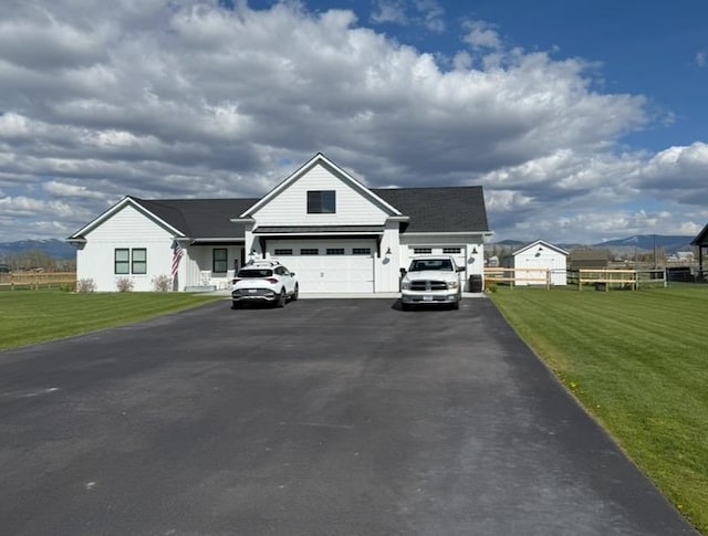modern inspired farmhouse featuring driveway, an attached garage, and a front yard