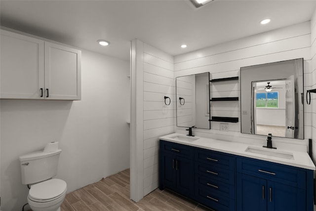 69571 Big Sam Ln, Arlee, MT 59821 - full bathroom with double vanity, wood finish floors, toilet, and recessed lighting