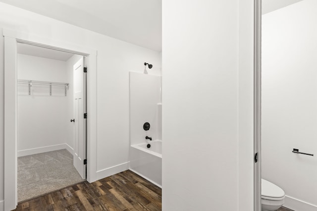 1503 3rd Ave NW, Great Falls, MT 59404 - bathroom with wood finished floors, shower / washtub combination, toilet, a walk in closet, and baseboards