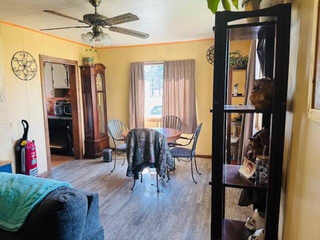 dining room with ceiling fan, wood finished floors, and baseboards