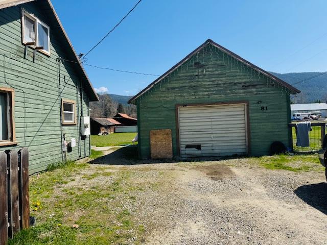 detached garage with a mountain view and dirt driveway