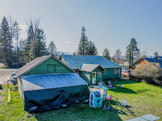 rear view of house featuring metal roof and a lawn