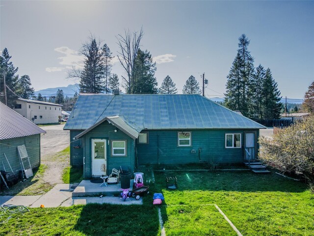 rear view of property featuring a yard and a patio area
