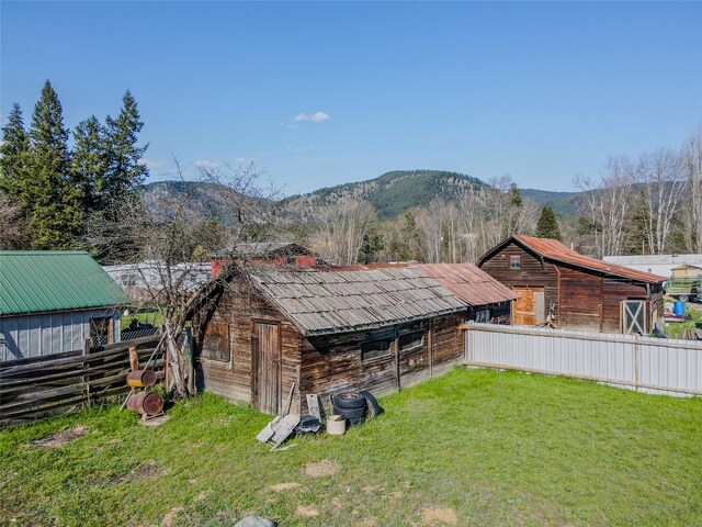 exterior space featuring fence, a lawn, and a mountain view