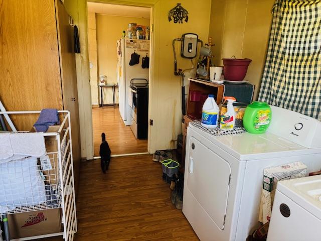 laundry area with washing machine and dryer, wood finished floors, and laundry area
