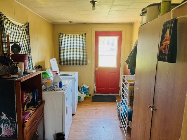 washroom featuring wood finished floors, independent washer and dryer, crown molding, and laundry area
