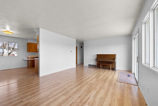 unfurnished living room featuring visible vents and light wood-style floors