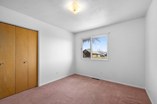 unfurnished bedroom with visible vents, carpet floors, and baseboards
