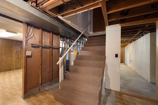 unfinished basement with stairs and gas water heater