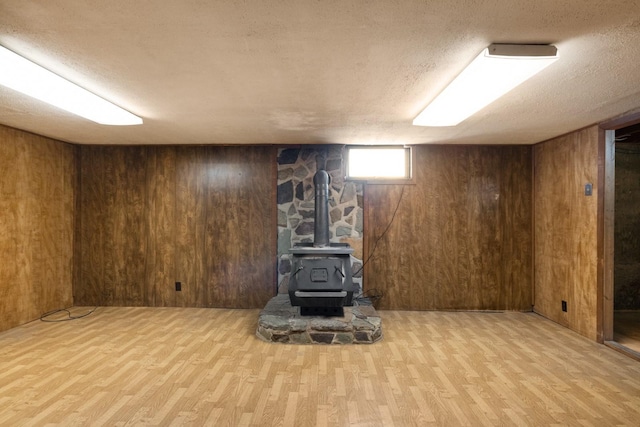 below grade area featuring wood walls, a textured ceiling, and wood finished floors