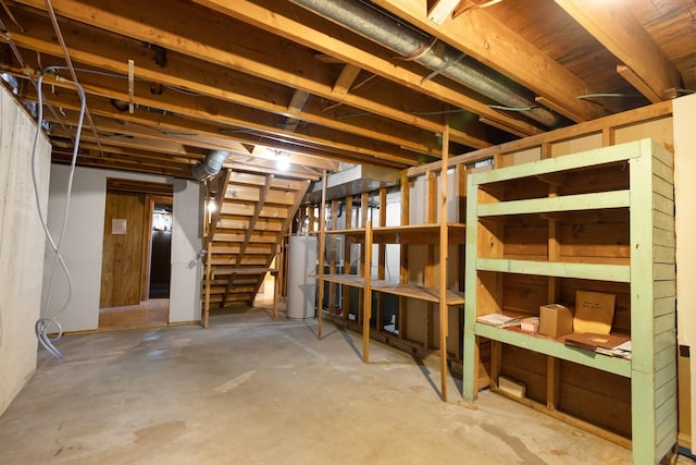 unfinished basement with gas water heater and stairway