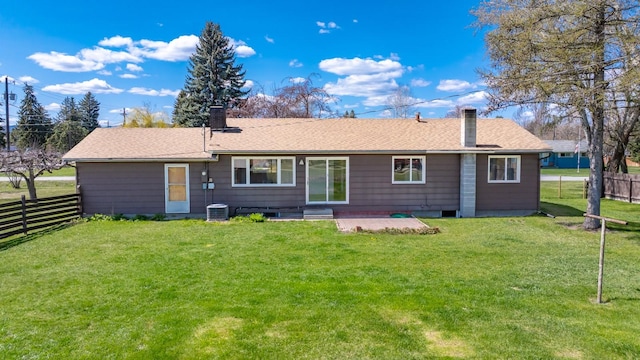 rear view of house featuring a yard, fence private yard, and a chimney