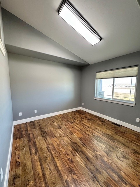 3554 Fasbender Ct, Helena, MT 59602 - empty room with lofted ceiling, dark wood-type flooring, and baseboards