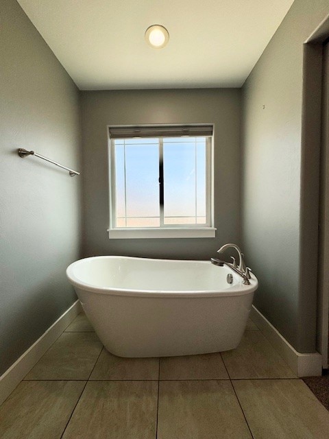 3554 Fasbender Ct, Helena, MT 59602 - full bath featuring baseboards, tile patterned flooring, and a freestanding tub