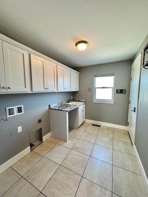 3554 Fasbender Ct, Helena, MT 59602 - laundry area featuring hookup for an electric dryer, cabinet space, hookup for a washing machine, light tile patterned floors, and baseboards